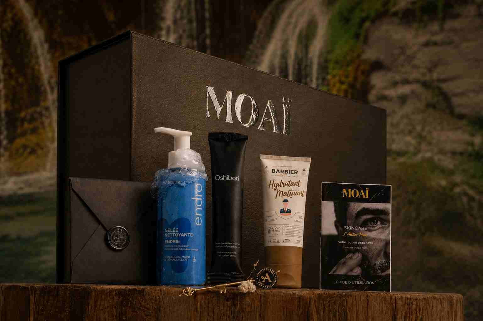 Coffret cadeau homme MOAÏ présenté avec une sélection de soins pour le visage, un guide de routine et une enveloppe cachetée. La mise en scène met en avant une routine complète de soins masculins dans un écrin élégant prêt à offrir.