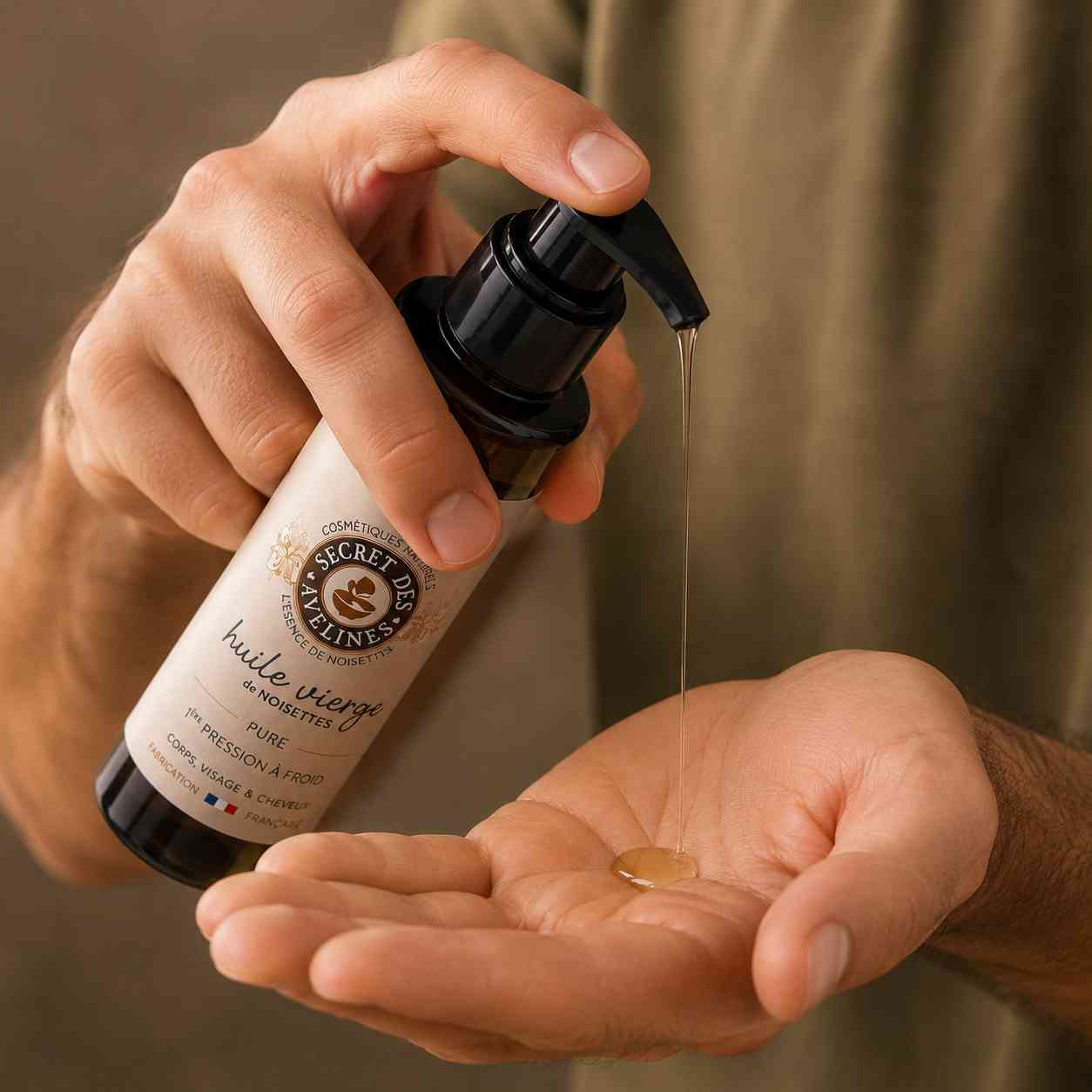 Homme appliquant l'huile vierge de noisette Secret des Avelines dans la paume de la main avant un soin du visage, de la barbe ou des cheveux