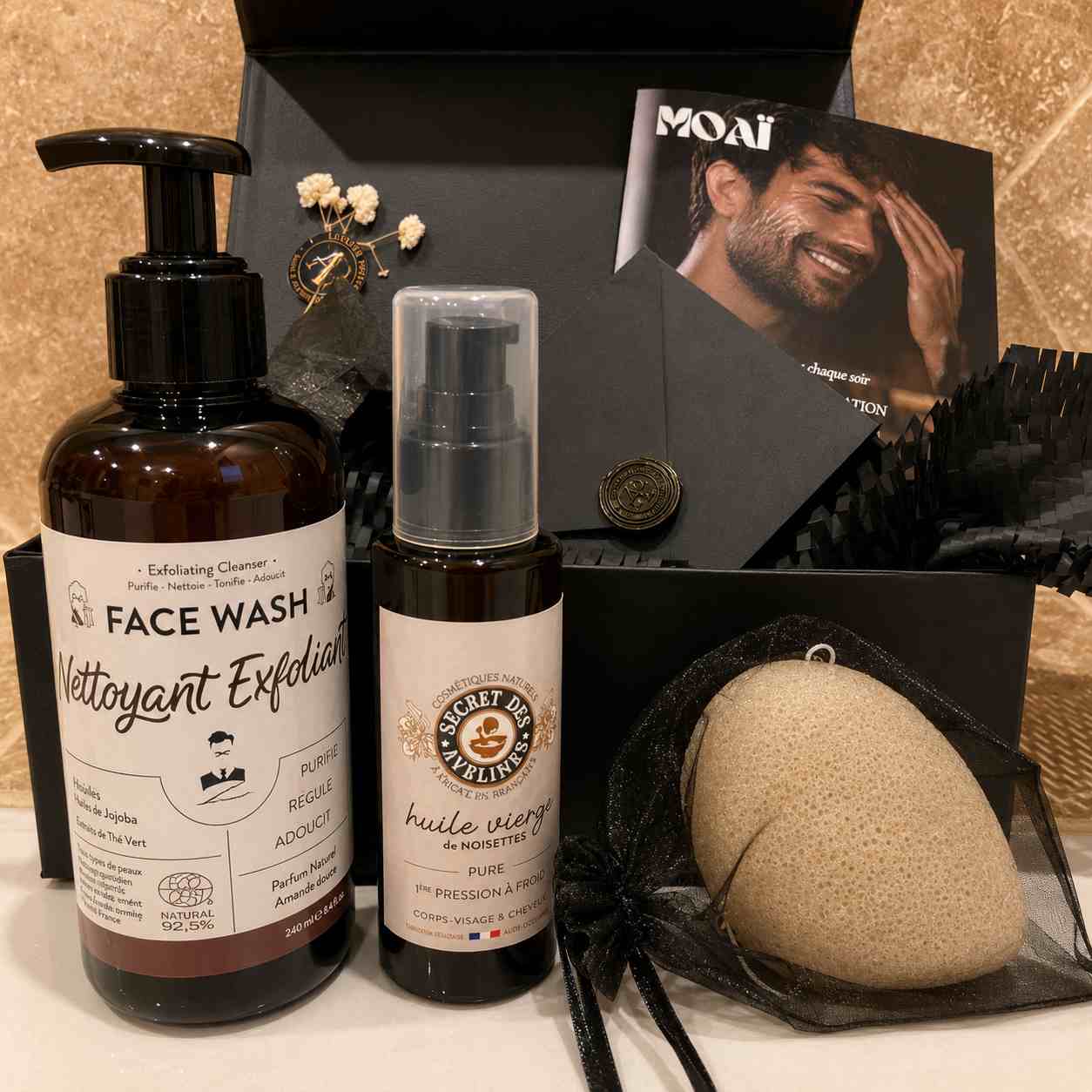 Coffret cadeau homme MOAÏ contenant un nettoyant visage exfoliant, une huile de noisette, une éponge Konjac et des accessoires de soins pour une routine skincare complète.