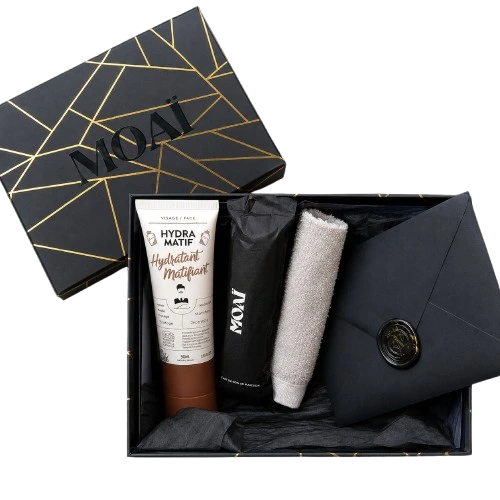 Coffret cadeau Moaï ouvert contenant un soin hydratant matifiant, des accessoires de soin et une enveloppe à sceau de cire.